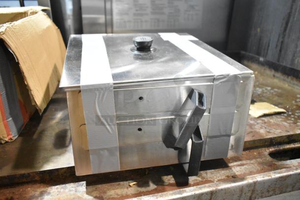 Brand new metal bin with some scratches and dents. Features sturdy handles and taped lid. Potential storage solution.