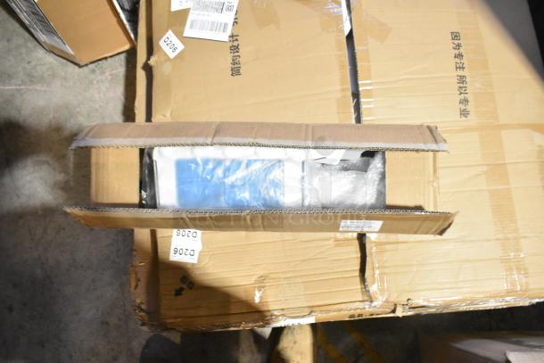 Box containing a brand new scratch and dent floor cleaner, partially open showing packaging. Labels with codes visible on top.