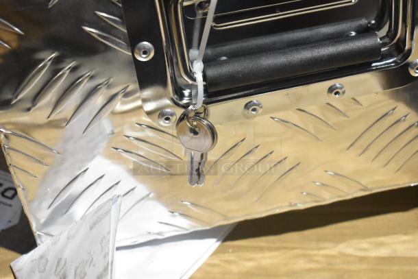 Diamond plate tool box with attached keys, showing sturdy metal construction and textured surface, part of auction lot.