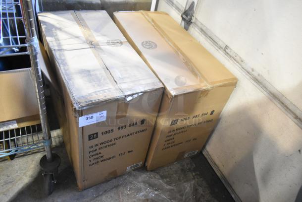 Two sealed cardboard boxes labeled "19 IN Wood Top Plant Stand," marked "Scratch and Dent," new condition, PO# 55161694.
