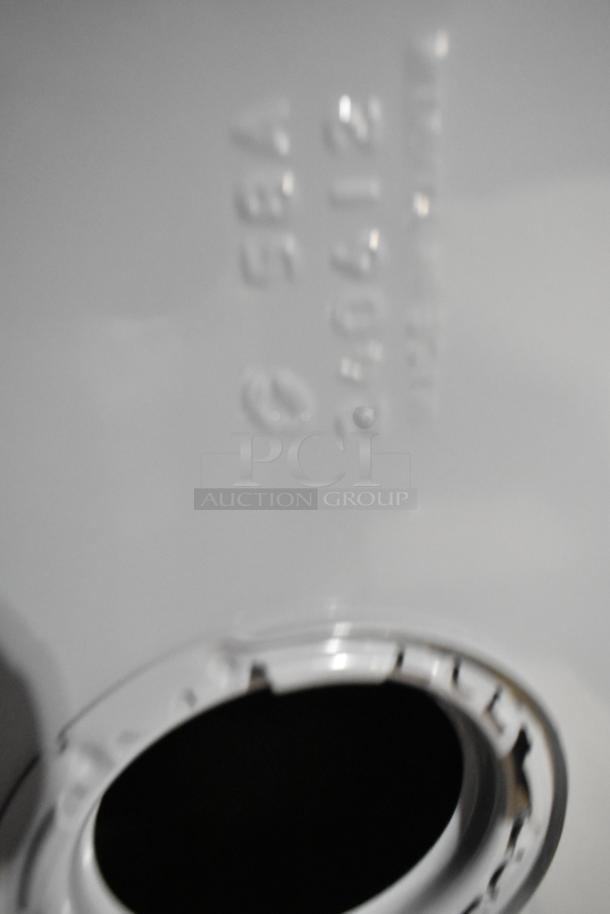 Gray metal unit with visible embossed markings, indicating model number and serial info. Circular opening detail shown.