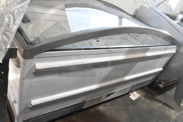 Metal commercial freezer merchandiser on casters, glass top, white finish, storage basket, label showing item number 340.