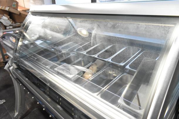 Sevel metal gelato case merchandiser with stainless steel drop-in bins, glass display front. Slight dust visible on surface.