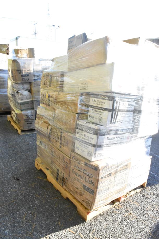 Pallet of various boxed items including straws and squat cups, wrapped in plastic. Packages show some wear and markings.