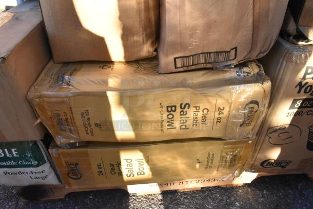 Boxes of 24 oz clear plastic salad bowls with lids, brand "Choice," new condition visible despite some packaging dents.