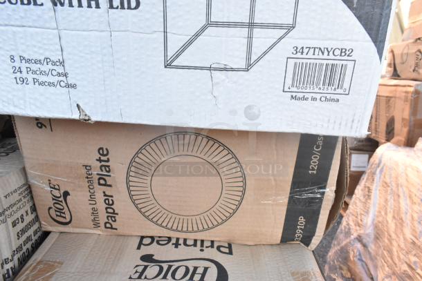 Boxes of scratch and dent items, including a dispenser and paper plates. Visible labels indicate packaging details.