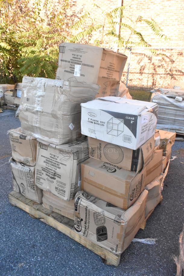 Stack of new scratch and dent items on a pallet, including labeled boxes of dispensers, mini cubes, and paper plates.