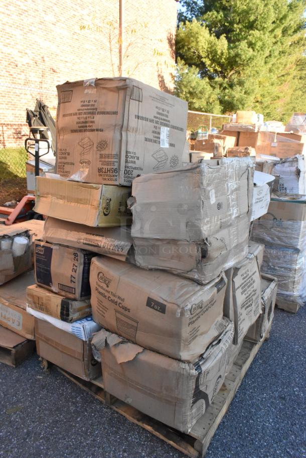 Pallet with boxes of scratch and dent items, including cups and plates, showing visible wear, taped and stacked outdoors.