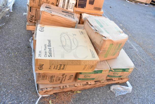 Boxes of brand new Choice clear plastic salad bowls, hot cups, and containers on a pallet. Some packaging is dented.