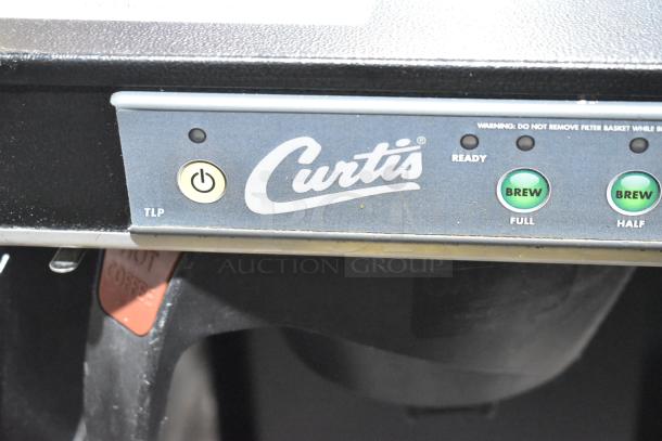 Brand new Curtis TLP low profile 18" automatic airpot brewer, black finish, 120V, with visible control panel and logo.