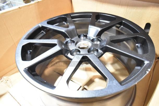 Box of two brand new GM 19303155 rims, sleek metallic finish, pristine condition, displayed inside the original packaging.