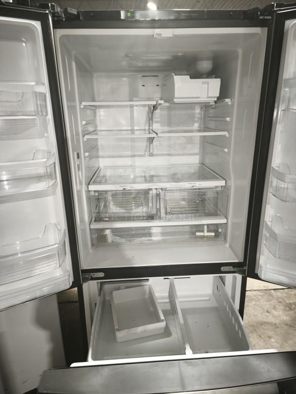 GE 27.7 Cu. Ft. fingerprint-resistant French-door refrigerator, stainless steel, Model GFE28GYNFS, open, showing spacious interior.