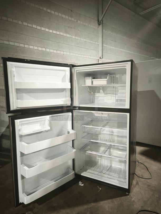 GE ENERGY STAR 21.1 cu. ft. top-freezer refrigerator GIE21GSHSS, open door view, internal shelves and bins visible.