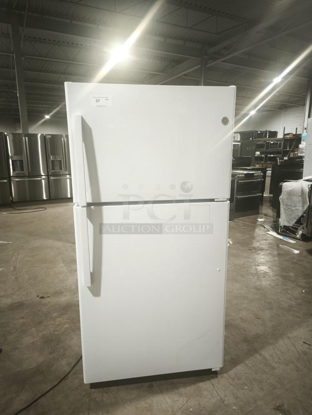 GE 21.9 cu ft garage-ready top-freezer refrigerator, model GTS22KGNRWW, in warehouse setting. Excellent condition.