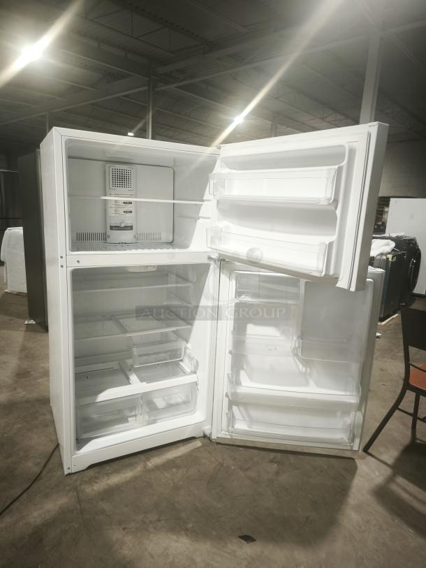 GE 21.9 cu ft garage-ready top-freezer refrigerator, model GTS22KGNRWW, open showing interior shelves and compartments.