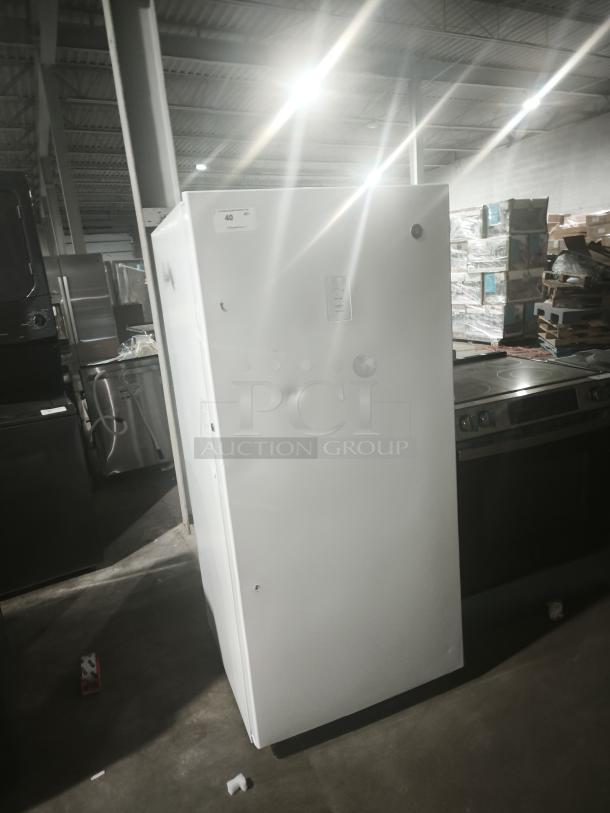 GE 14.1 Cu. Ft. Frost-Free Garage-Ready Upright Freezer, Model FUF14DLRWW, white, visible dents, warehouse setting.