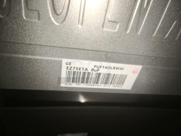 GE 14.1 Cu. Ft. Frost-Free Upright Freezer, Model FUF14DLRWW, features garage-ready design. Label shows model and serial number.