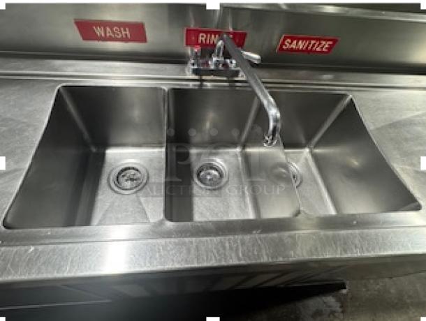 Three-compartment commercial sink with labeled sections: Wash, Rinse, Sanitize. Includes two-door cooler below. Stainless steel finish.