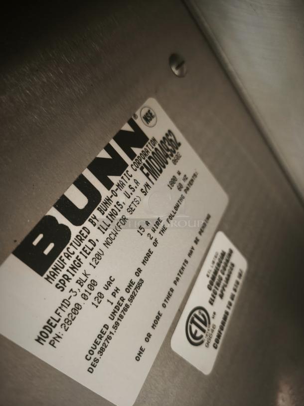 Label on BUNN FMD-3 Fresh Mix Hot Drink Dispenser showing model, voltage, and certification details.