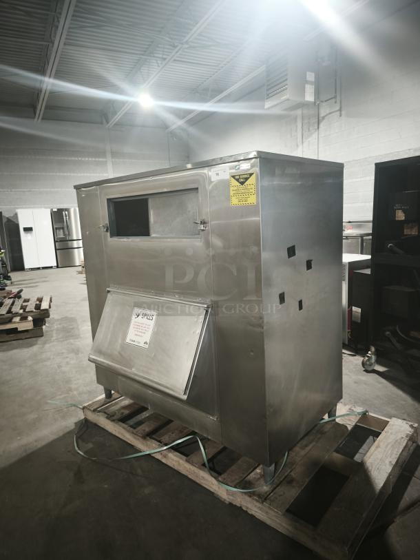 MGR Equipment SP-1650-SS ice storage bin, stainless steel, visible signage about spills, in good condition on a pallet.