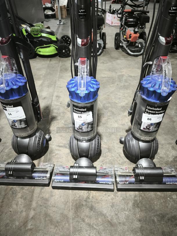 Dyson Ball Multi Floor 2 vacuums, model UP19, with blue cyclone assembly and clear dustbin. Tags label them as "Unrivaled Dyson suction."