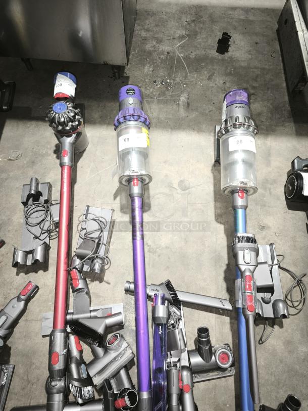 Dyson V11 Torque Drive PLUS cordless vacuum cleaner, in good condition. Includes multiple attachments and accessories. Labels with numbering visible on units.