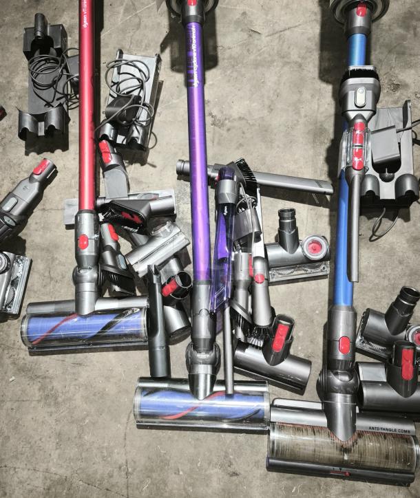 Dyson V11 Torque Drive PLUS cordless vacuum cleaner with several attachments, shown in good condition on a concrete floor.