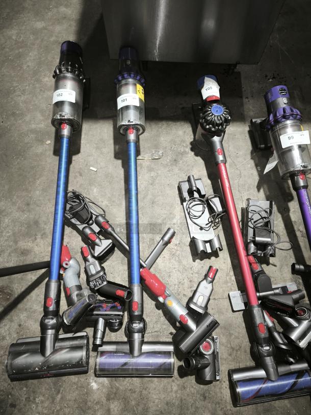 Dyson V11 Torque Drive PLUS cordless vacuum cleaners in blue and red, with attachments, visible labels indicating quantity.