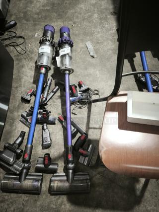 Dyson V11 Torque Drive PLUS cordless vacuum, includes multiple attachments, visible usage marks, tags "103" and "104."