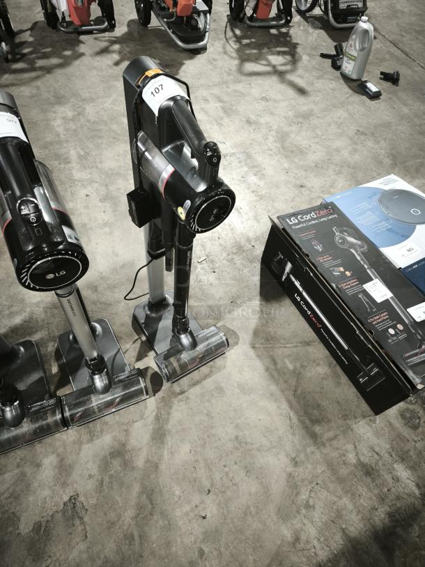 LG CordZero A9 Cordless Stick Vacuum A916BM on display, near its box, showing labeling and accessories on a concrete floor.