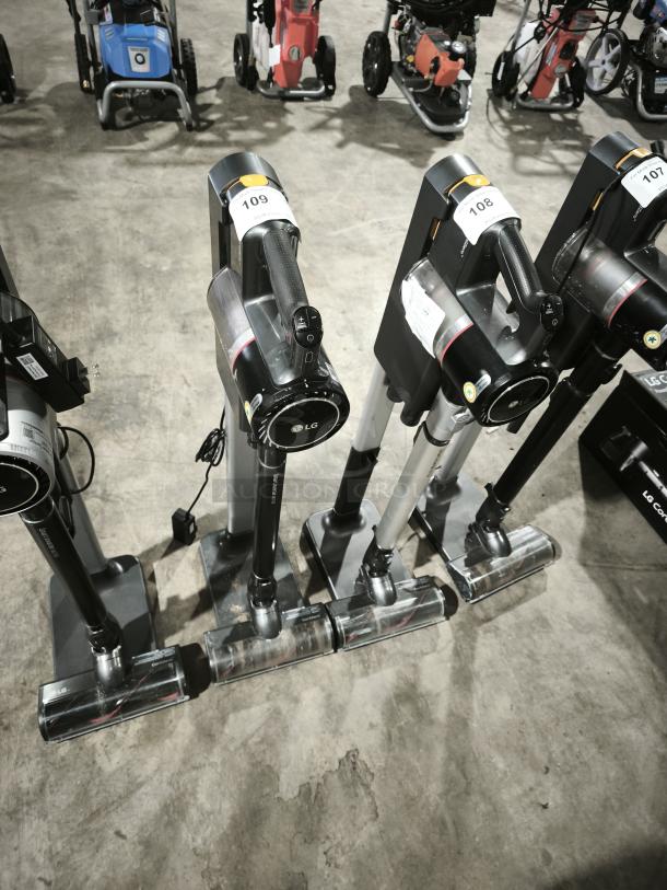 LG CordZero A9 cordless stick vacuums, model A916BM, displayed in a row. Includes visible auction tags, good condition.