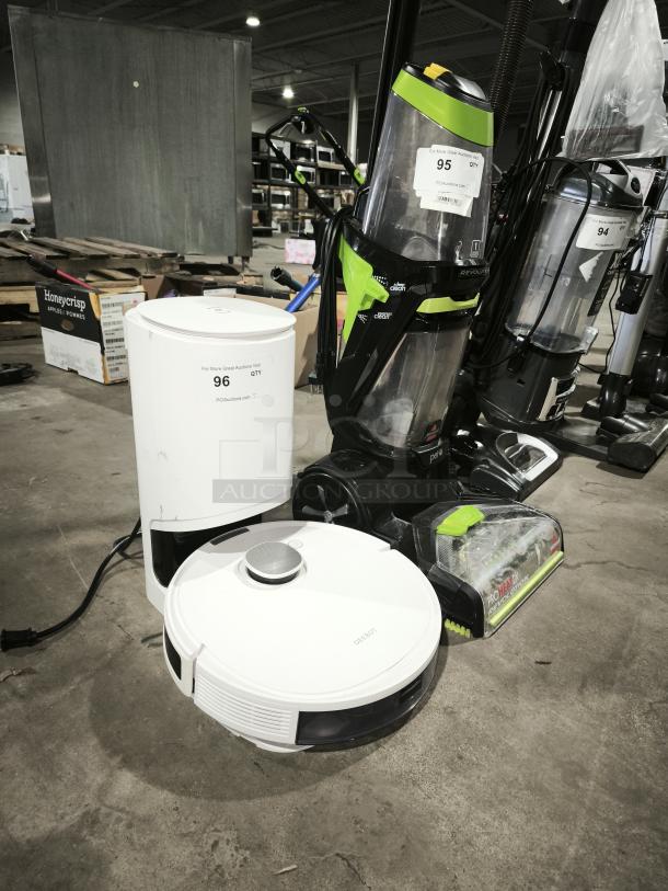White DEEBOT robotic vacuum and charging base, in good condition. Visible markings: "For More Great Auctions Visit PCAuctions.com."