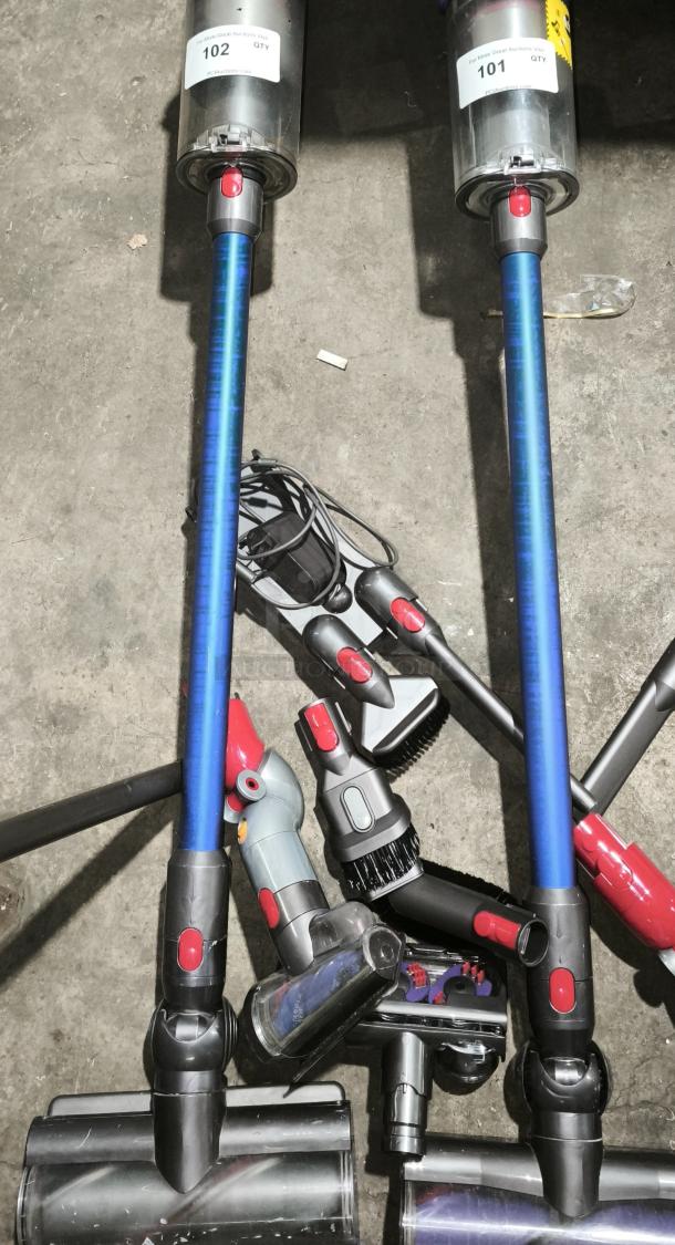 Dyson V11 Torque Drive PLUS cordless vacuum with blue stick, attachments, and visible auction labels 101, 102. Excellent condition.