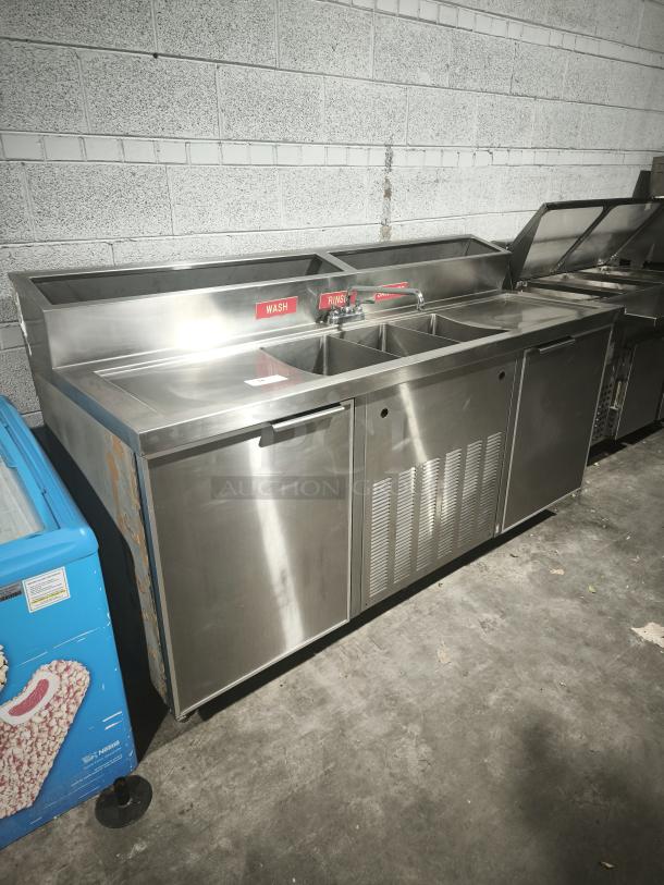 Three compartment stainless steel sink with dual-door cooler, labeled "Wash" and "Rinse." Ideal for restaurants.