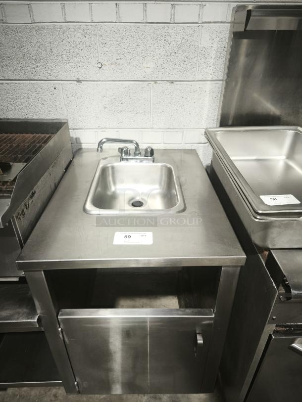 Stainless steel custom table with single sink, integrated faucet, and lower cabinet. Auction label "59" visible on top.