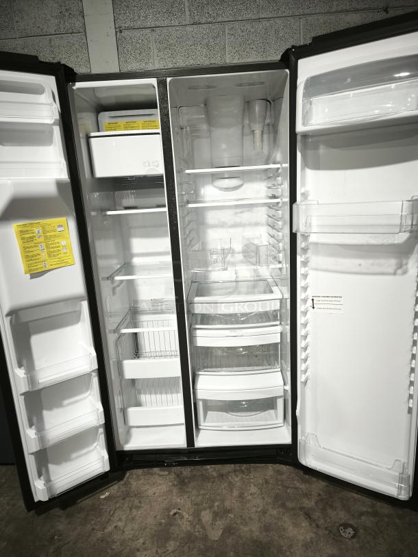 GE 21.8 cu ft counter-depth side-by-side refrigerator, model GZS22IYNFS. Fingerprint-resistant stainless steel. Open doors showing spacious interior with shelves, drawers, and door compartments. New condition.