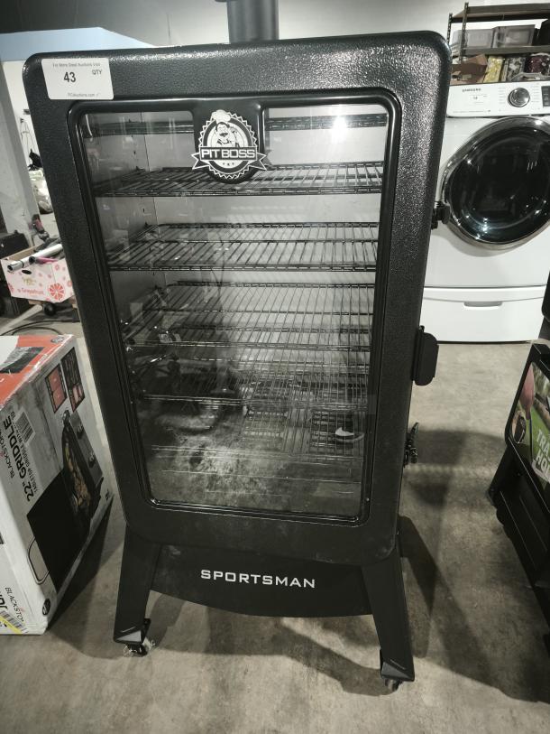 Pit Boss Sportsman 7-Series Wood Pellet Smoker 11110, new, black, multiple racks, visible logo, caster wheels, auction tag.