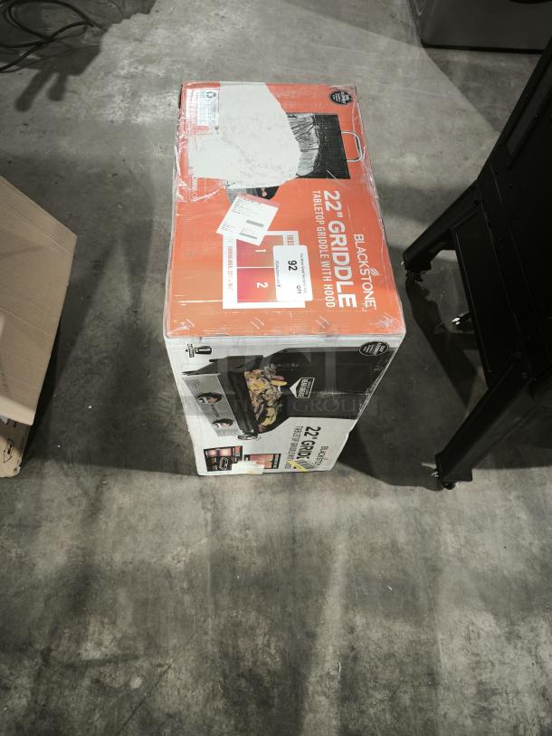 Brand new Blackstone 22" tabletop griddle with hood, model 2205, in sealed box. Box shows product image and features.