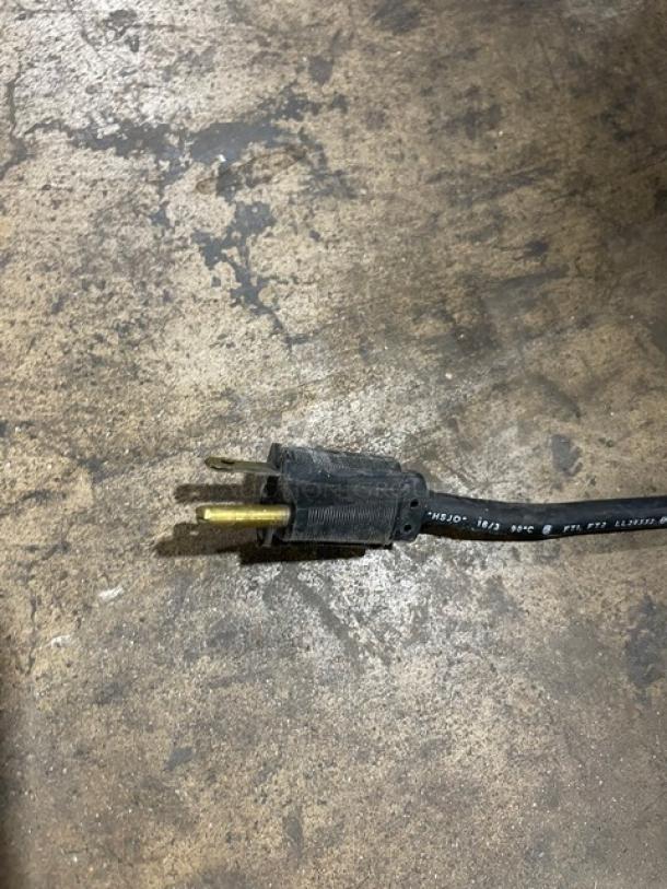 A black electrical cord with a plug, likely for a kitchen appliance. The cord shows text markings indicating specifications.