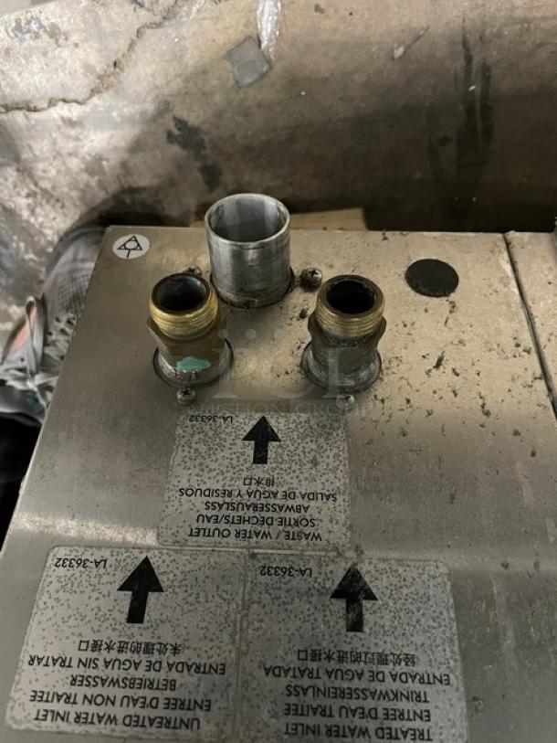 Alto-Shaam CTP720E commercial combi oven fittings with labels indicating waste outlet and water connections.