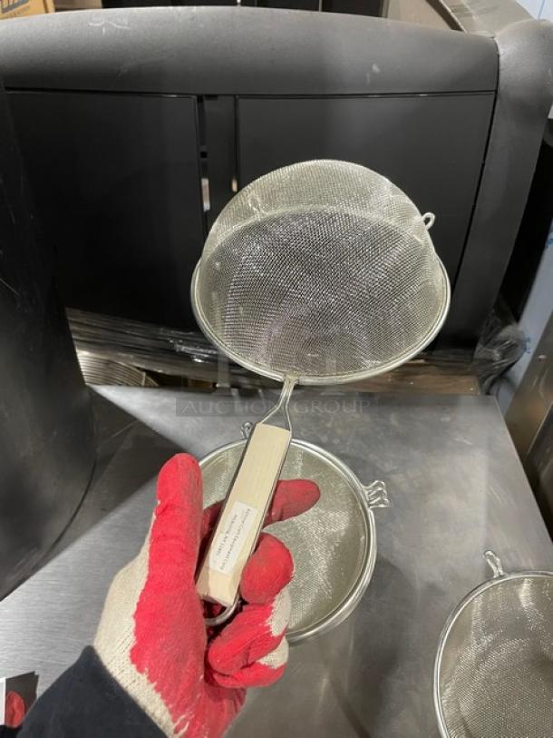 Adcraft SGTN-8 mesh strainer, 8" tinned steel, new condition. Features wooden grip handle, ideal for commercial use.