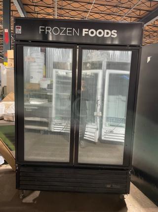 True GDM-49F commercial black double glass door freezer; features poly-coated wire rack, casters, and "Frozen Foods" label.