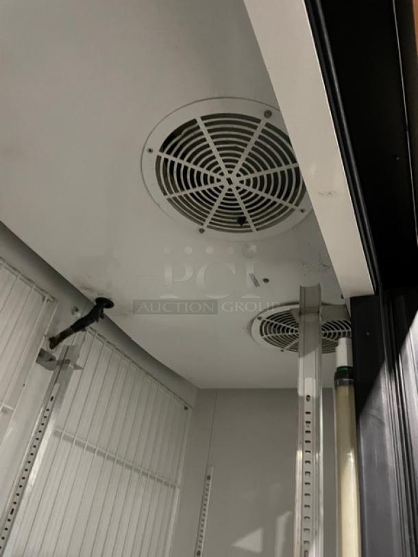 True GDM-49F commercial freezer interior. Double glass swing doors, poly coated wire racks, on casters. Model SN: 1-4780407.