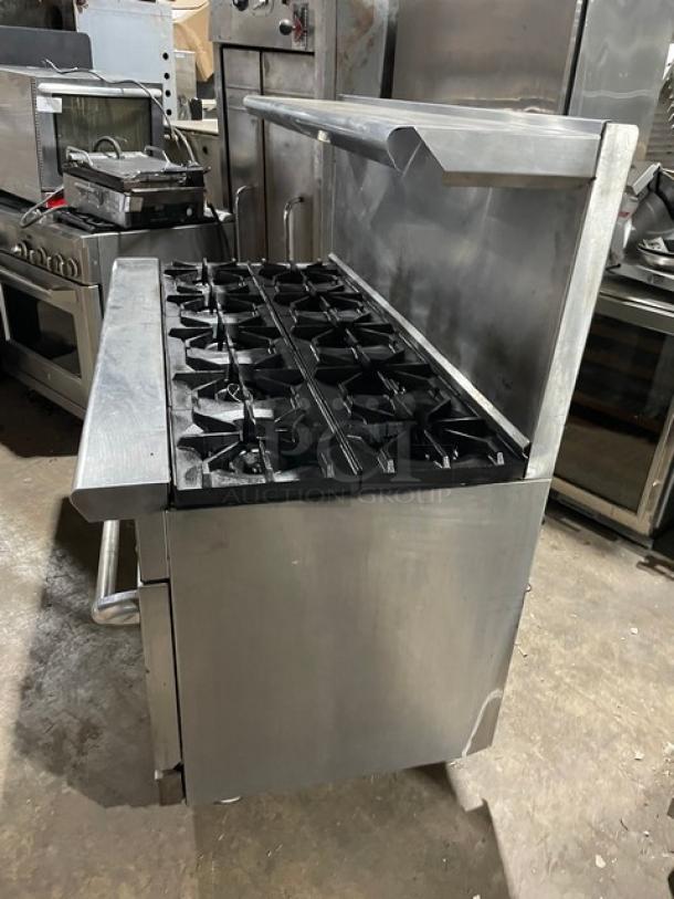 American Range 10-burner stainless steel gas range with double ovens, backsplash, salamander shelf, on casters.