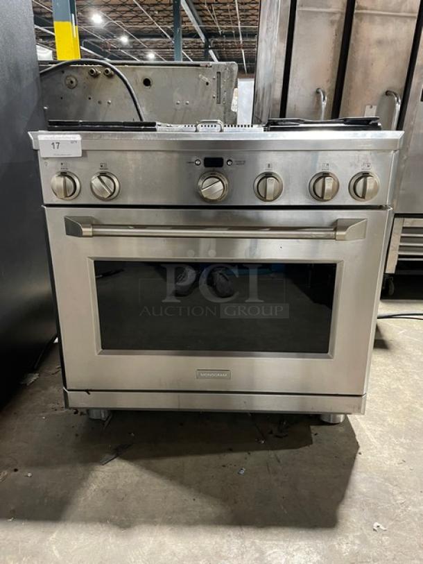 Monogram stainless steel 4-burner gas range/oven combo, visible knobs and wired oven rack, in good condition.