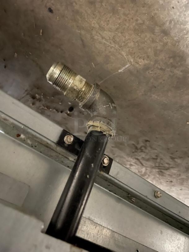 Monogram gas-powered 4-burner range/oven combo with stainless steel finish and wired oven rack. Features sturdy legs.