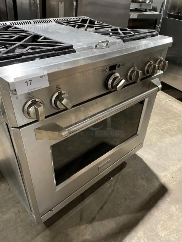Monogram stainless steel 4-burner gas range/oven combo, with wired oven rack, on legs. Knobs and handle intact.