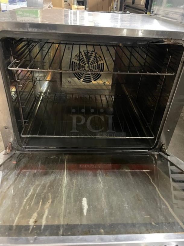Avantco commercial stainless steel countertop convection oven, model 177CO28, with wired rack and fan, showing clean interior.