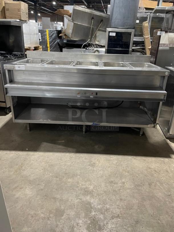 Delfield stainless steel gas-powered 5-well heated steam table with lower tray slide, single undershelf, and upturned backsplash.