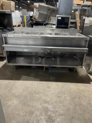 Delfield stainless steel gas-powered 5-well heated steam table with lower tray slide, single undershelf, and upturned backsplash.